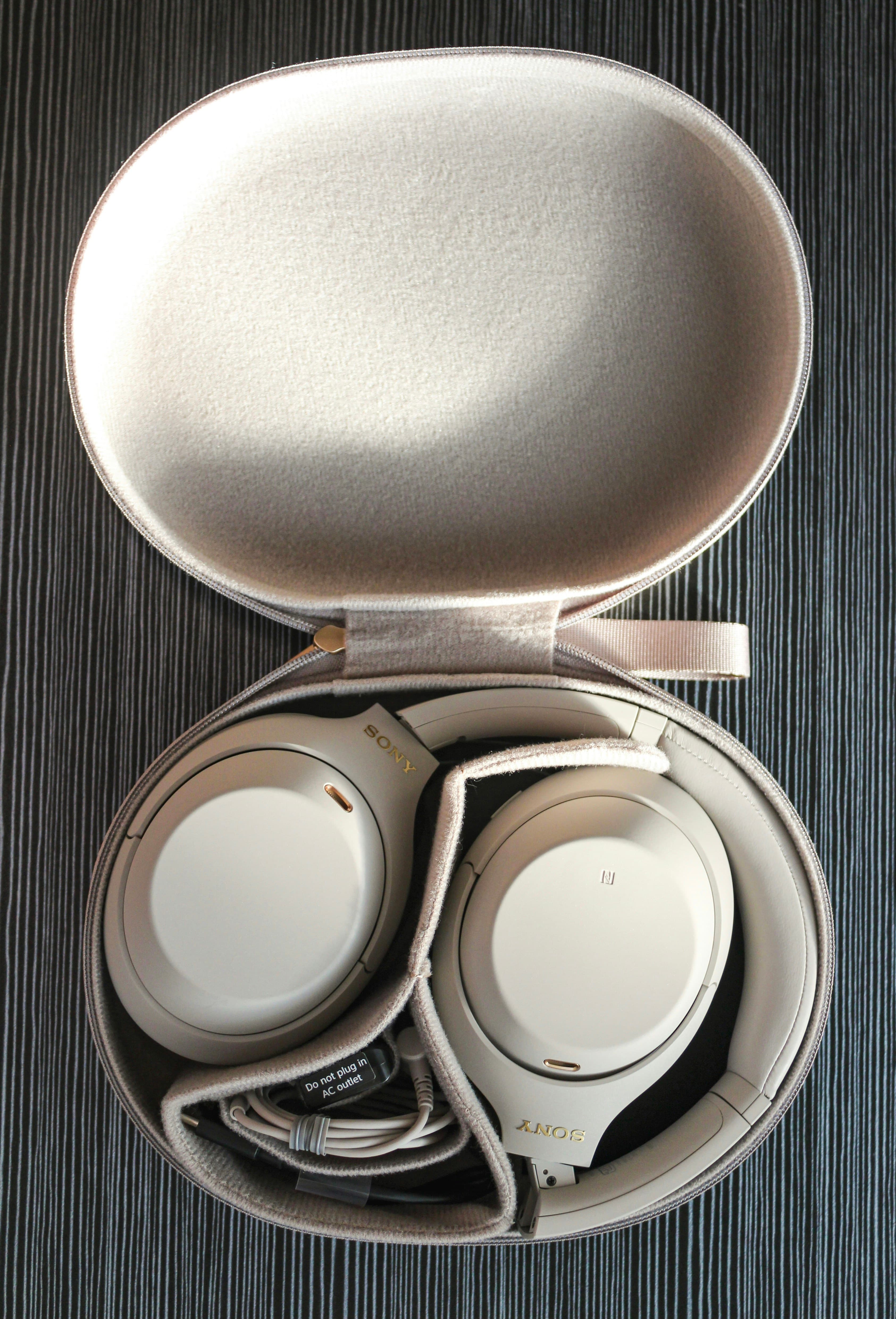 Headphone carrying case opened showing headphones inside protective pouch