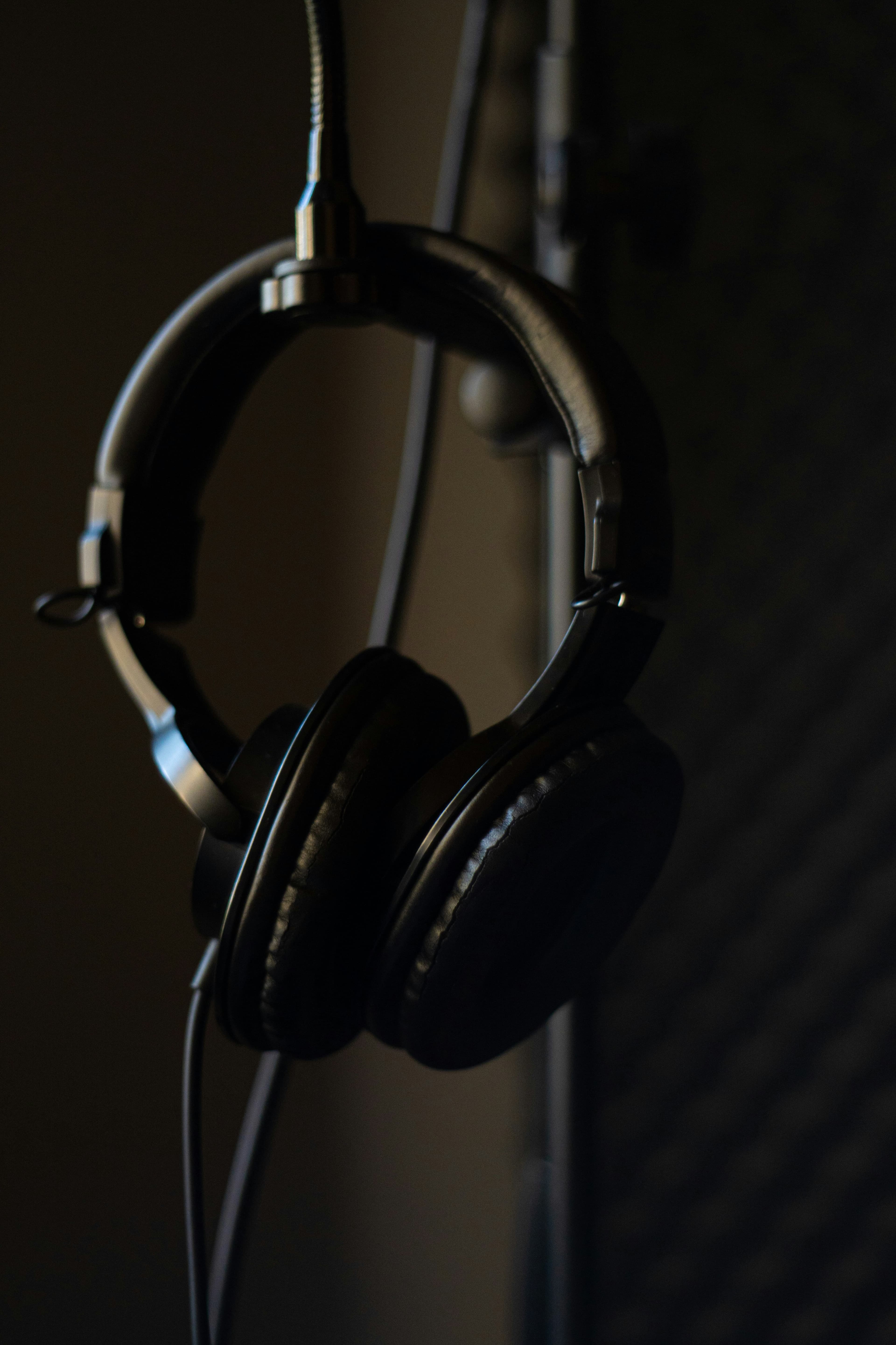 Black over-ear headphones worn by person in studio environment side profile
